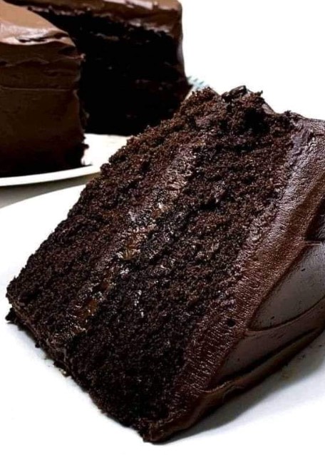 A rich, moist slice of chocolate buttermilk cake layered with velvety chocolate frosting, showcasing its soft texture and deep chocolatey goodness.