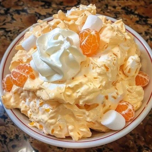 Orange Fluff Salad in a bowl garnished with mandarin oranges and marshmallows.